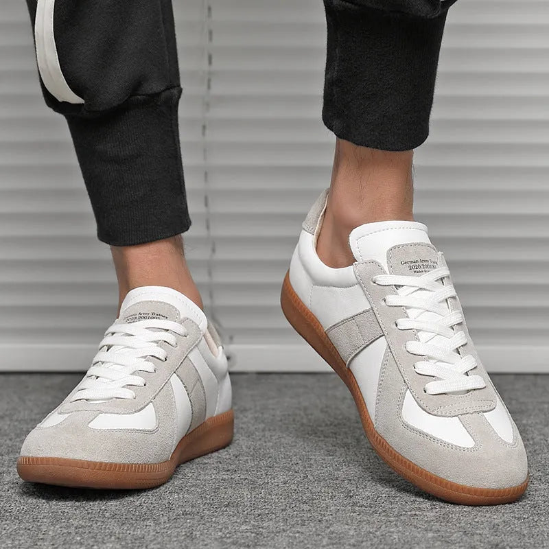 White Japanese retro low-top sneakers with round toe and lace-up front on a rubber sole.