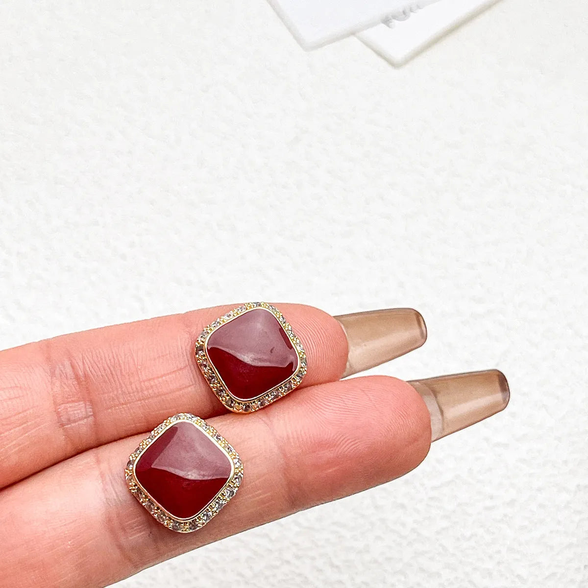 Red geometric square earrings with inlaid design details on alloy material