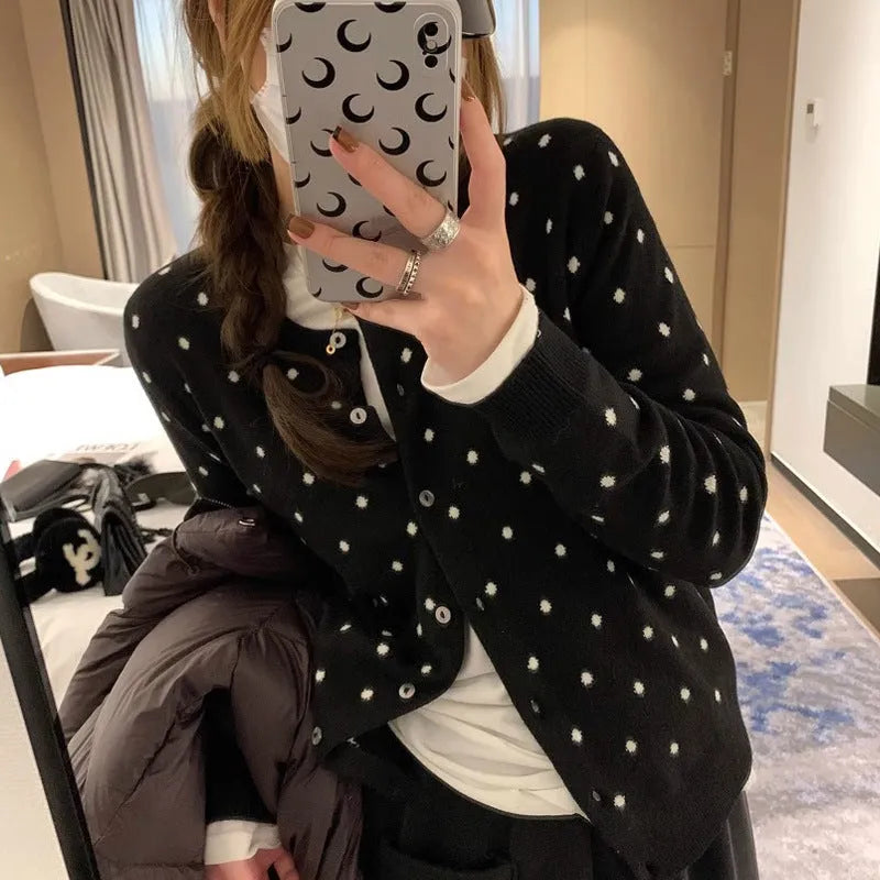 Women's grey dot knitted cardigan with long sleeves and crocheted flower detail.