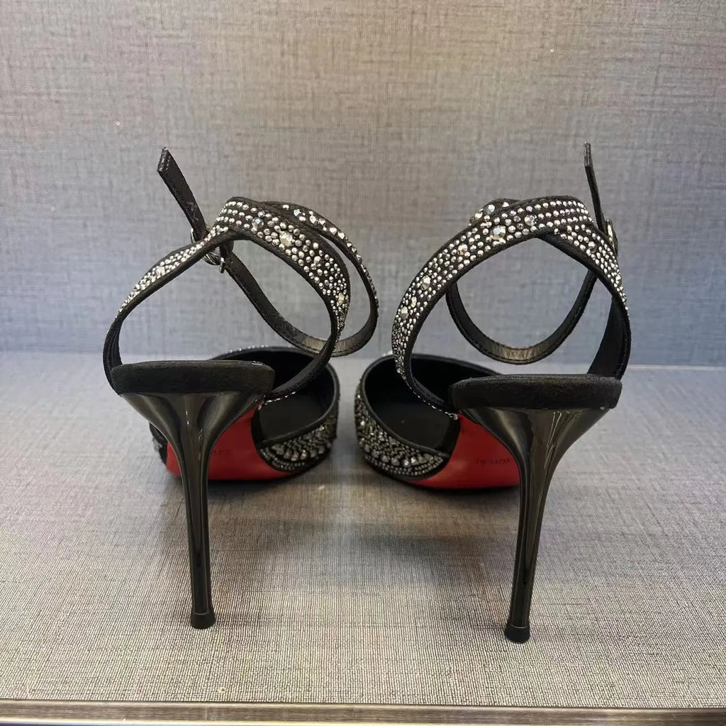 Women's black hollow cut stiletto high heels with pointed toe and red sole on a white background