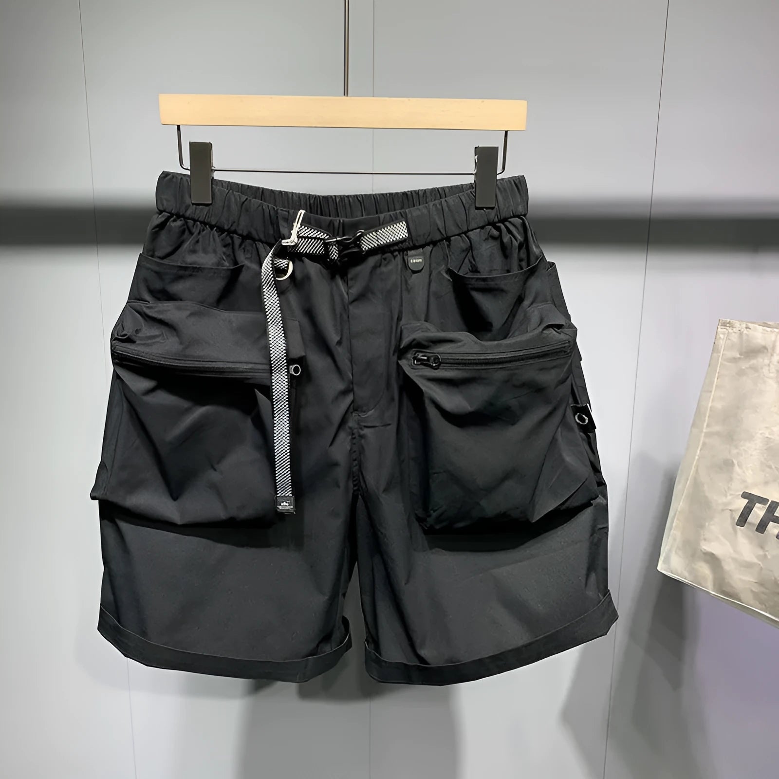Men's loose fit black work shorts with pockets, shown on a model