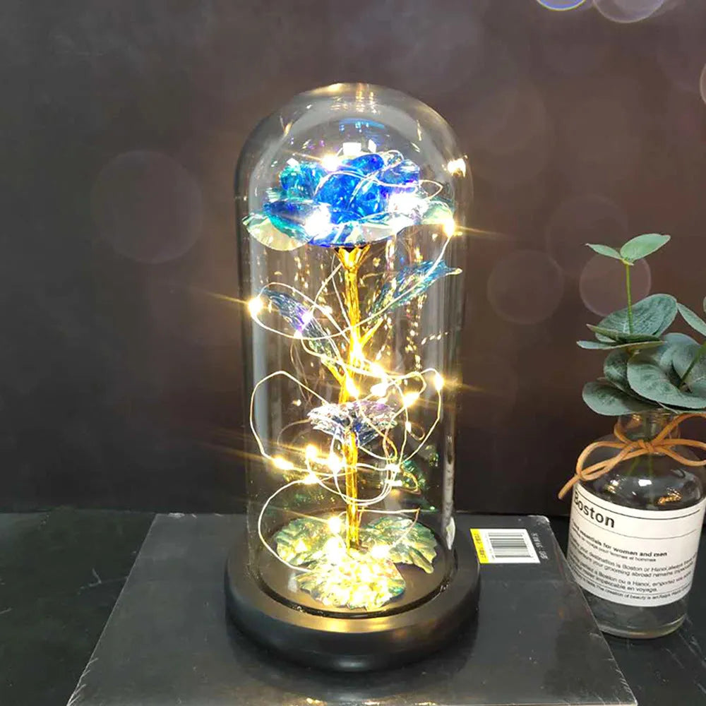 LED silk rose bouquet with glass lampshade glowing with warm white light on a solid wood base.