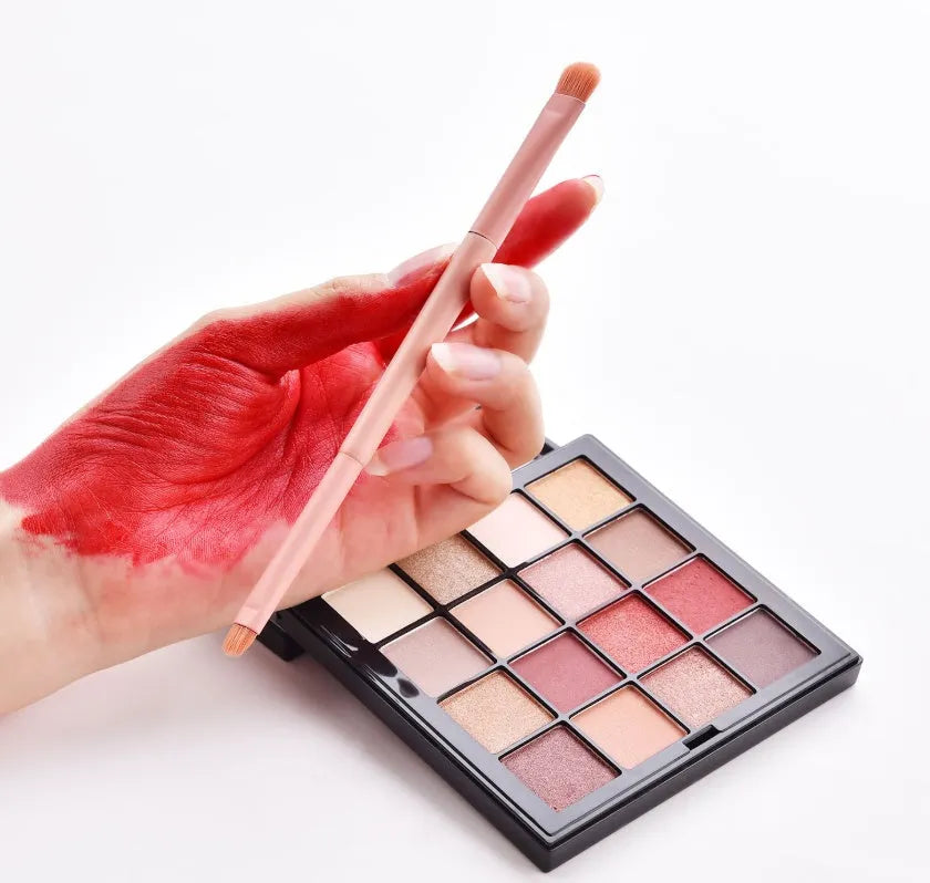 Ten professional makeup brushes with wooden handles arranged in a set, including powder, foundation and detail brushes