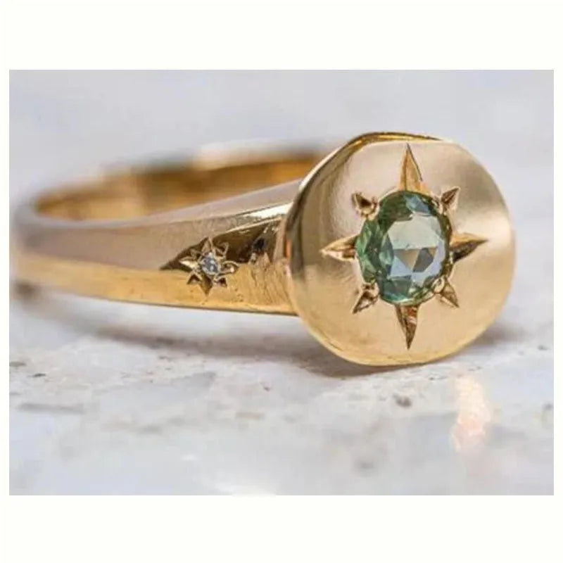 Gold ring with star-shaped asterism pattern and adjustable opening.