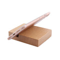 Beech wood and resin mobile phone holder bracket in a decorative animal design on a desk.