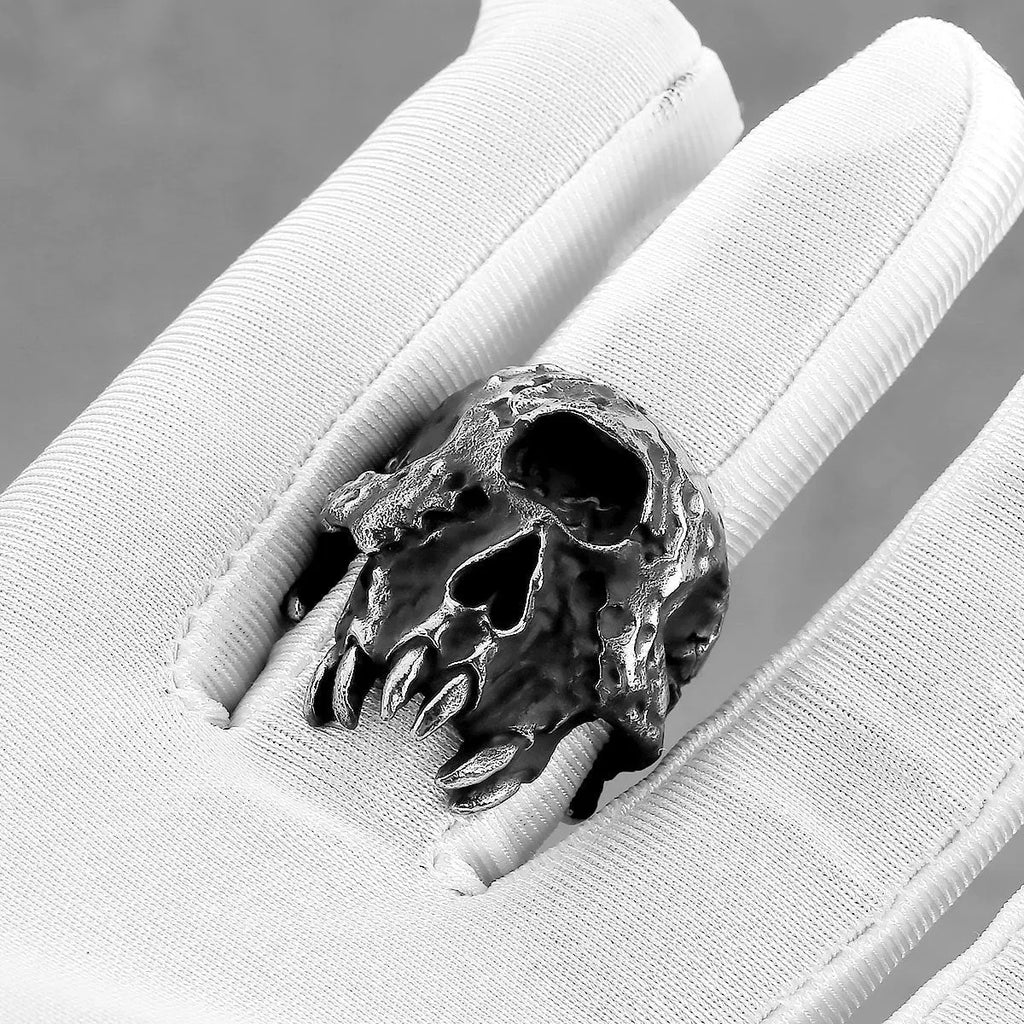 Close-up of a retro alloy ring with a detailed one-eyed skull design on a dark background.