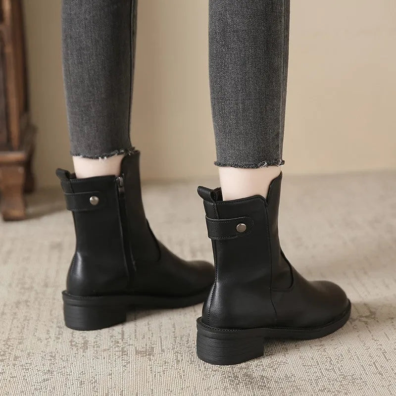 Black women's ankle boots with side zip and low round toe on a rubber sole.