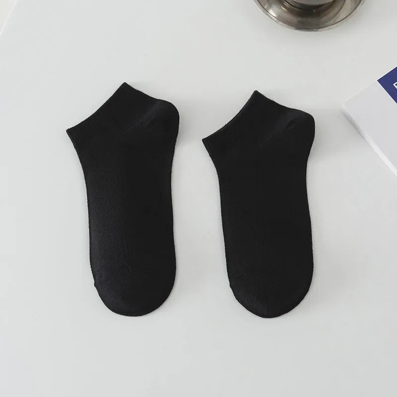 A pair of solid colour low-cut men's boat socks made from breathable polyester fabric.