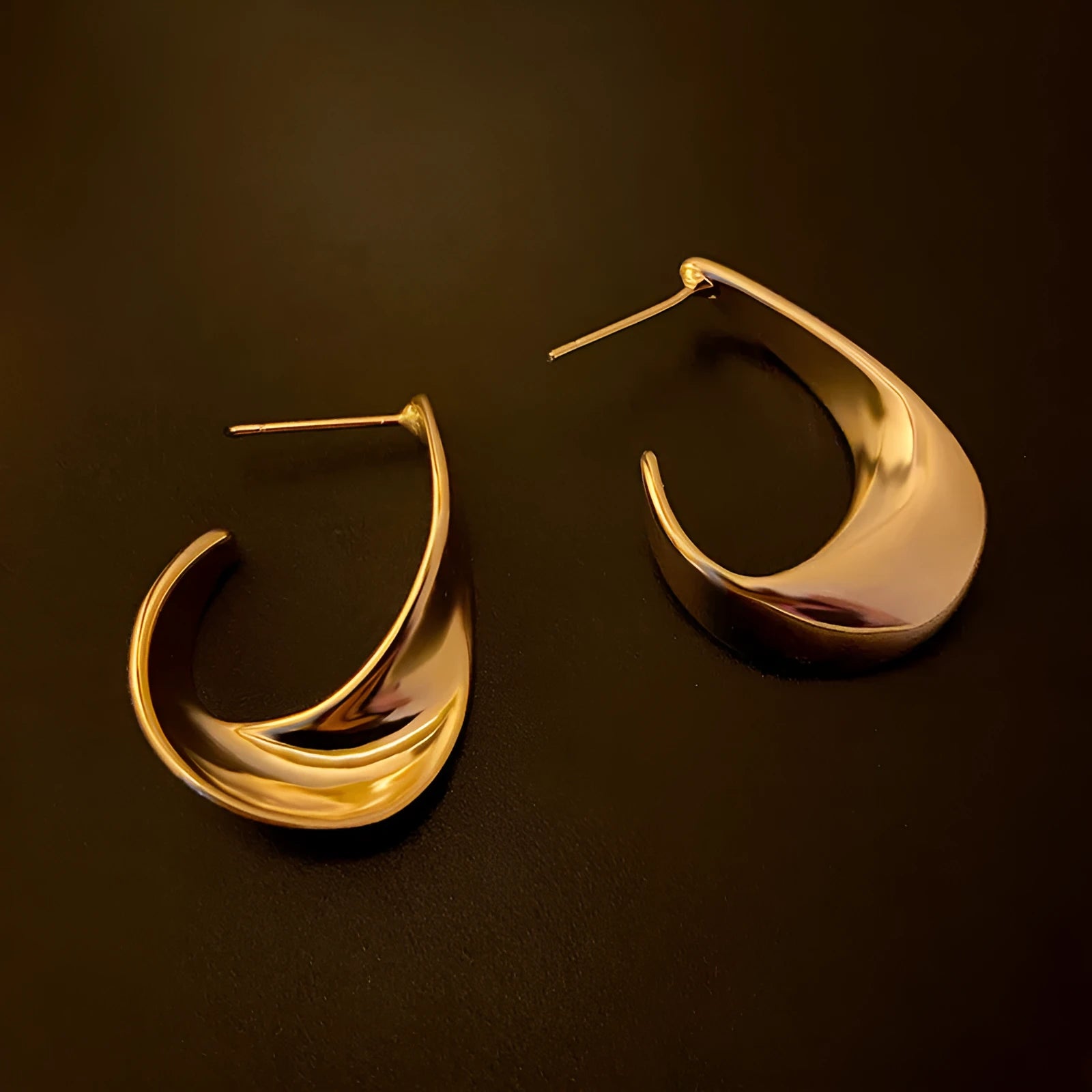 Metal twisted geometric earrings with electroplated gold or silver finish showing round design elements