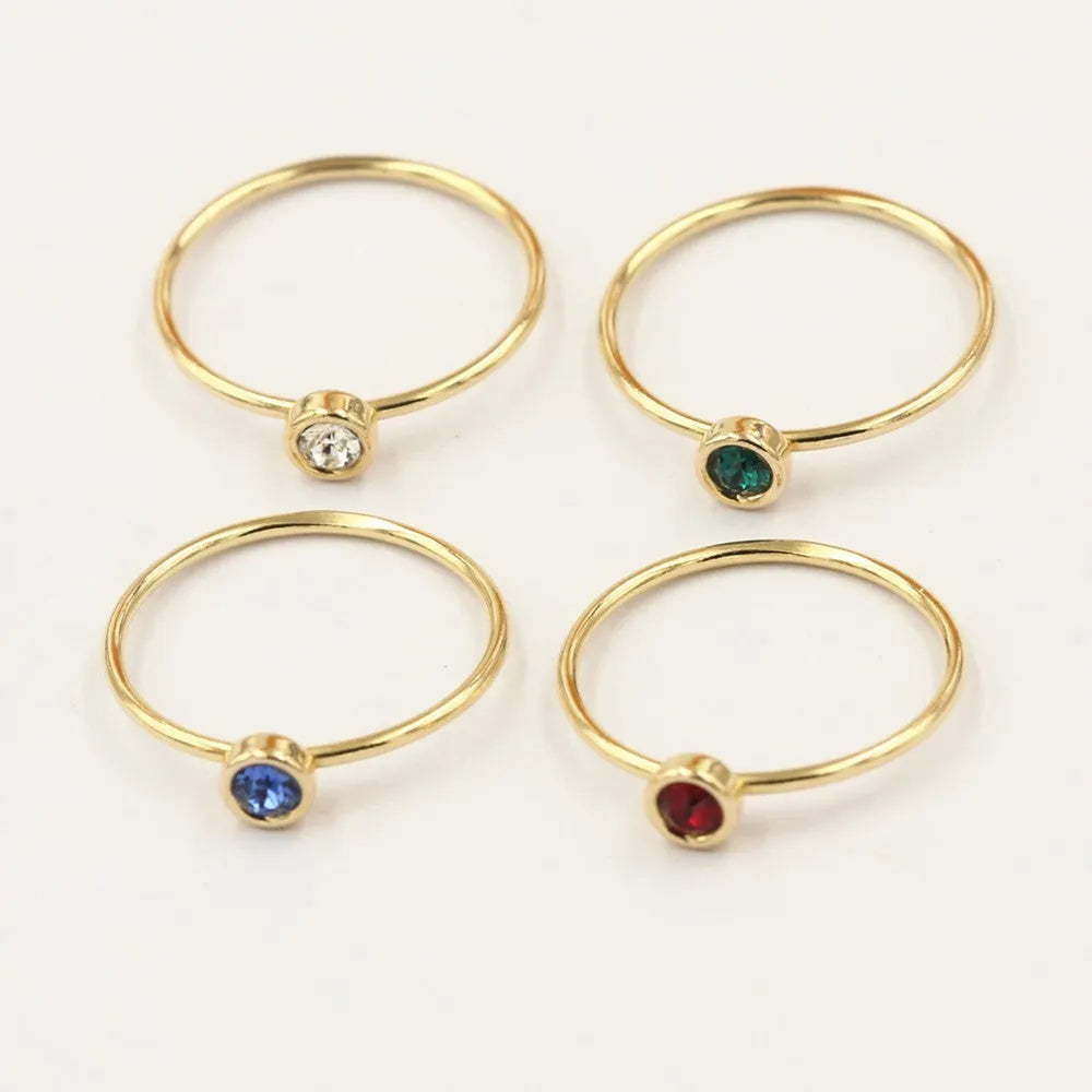 14K gilded gold filled zircon ring on a finger, showing green colour and zircon stones.