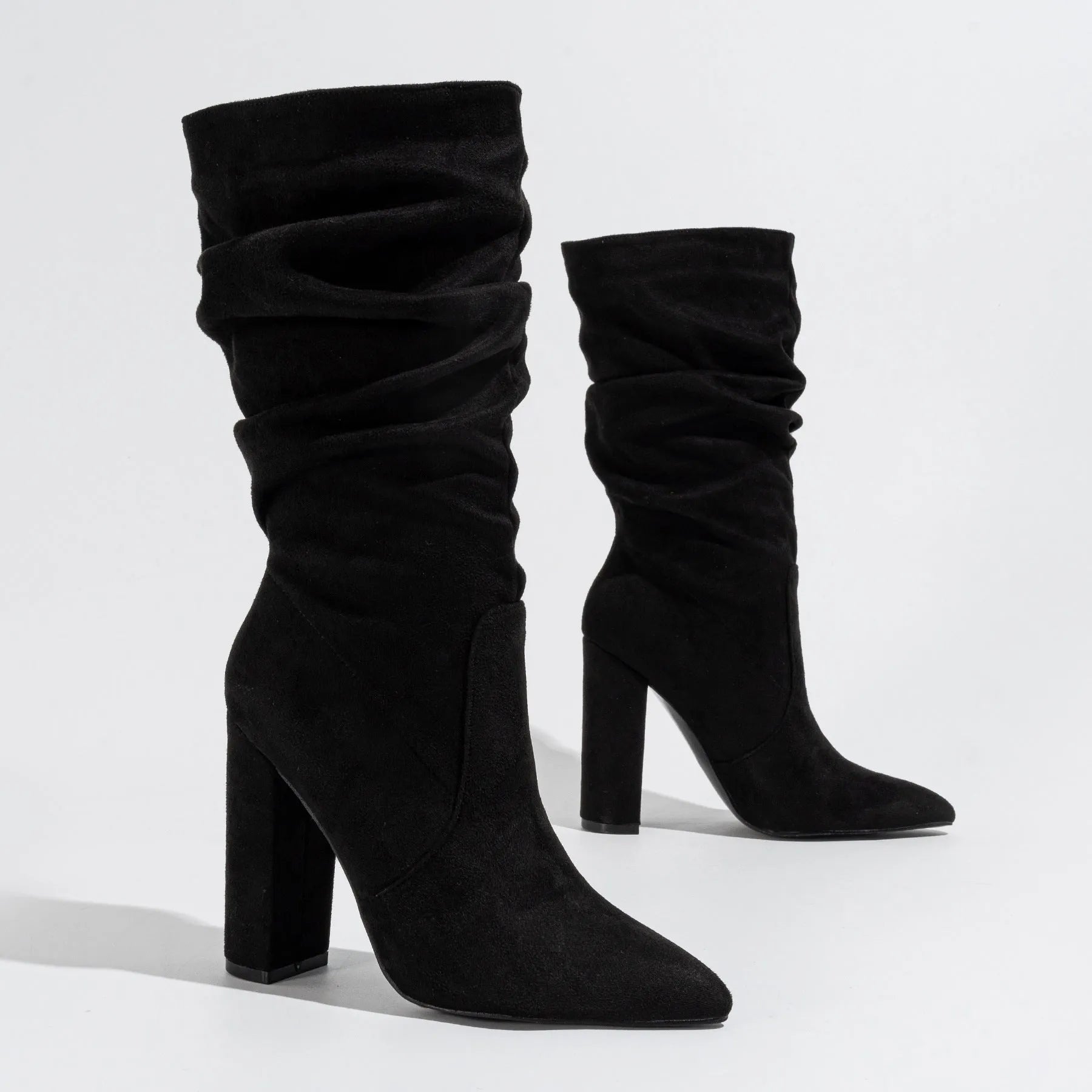 Black suede women's boots with a pointed toe and a thick chunky high heel, mid-calf length.