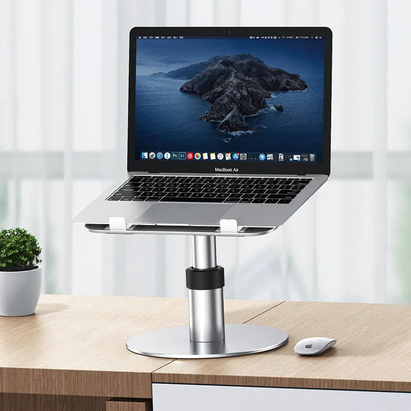 Silver adjustable aluminium laptop stand with rotating base on a desk.