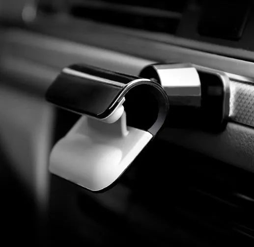 Black car phone holder with 360-degree rotating mechanism mounted on dashboard