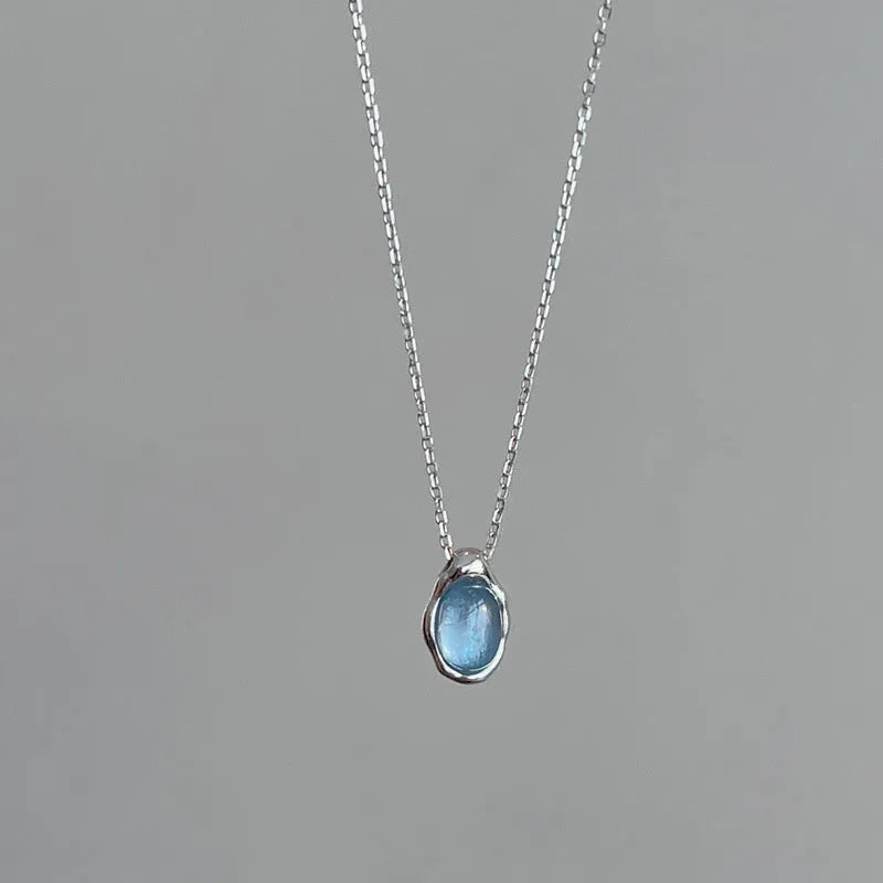 Navy blue geometric water drop pendant necklace with cross chain design on white background