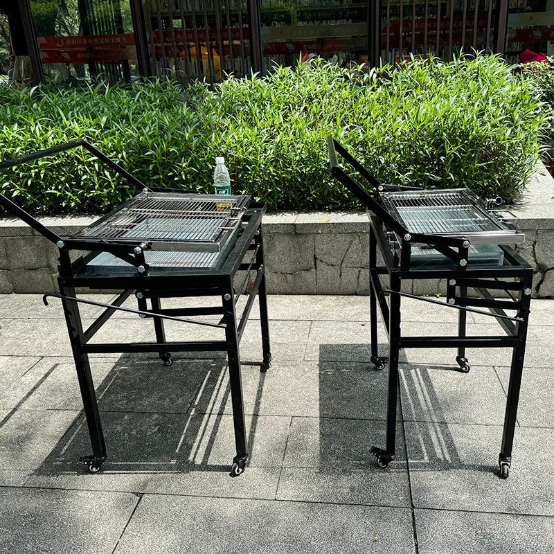 Large foldable and detachable charcoal BBQ grill oven set up in an outdoor courtyard setting.