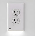 White plug-in LED sensor night light installed in a wall socket