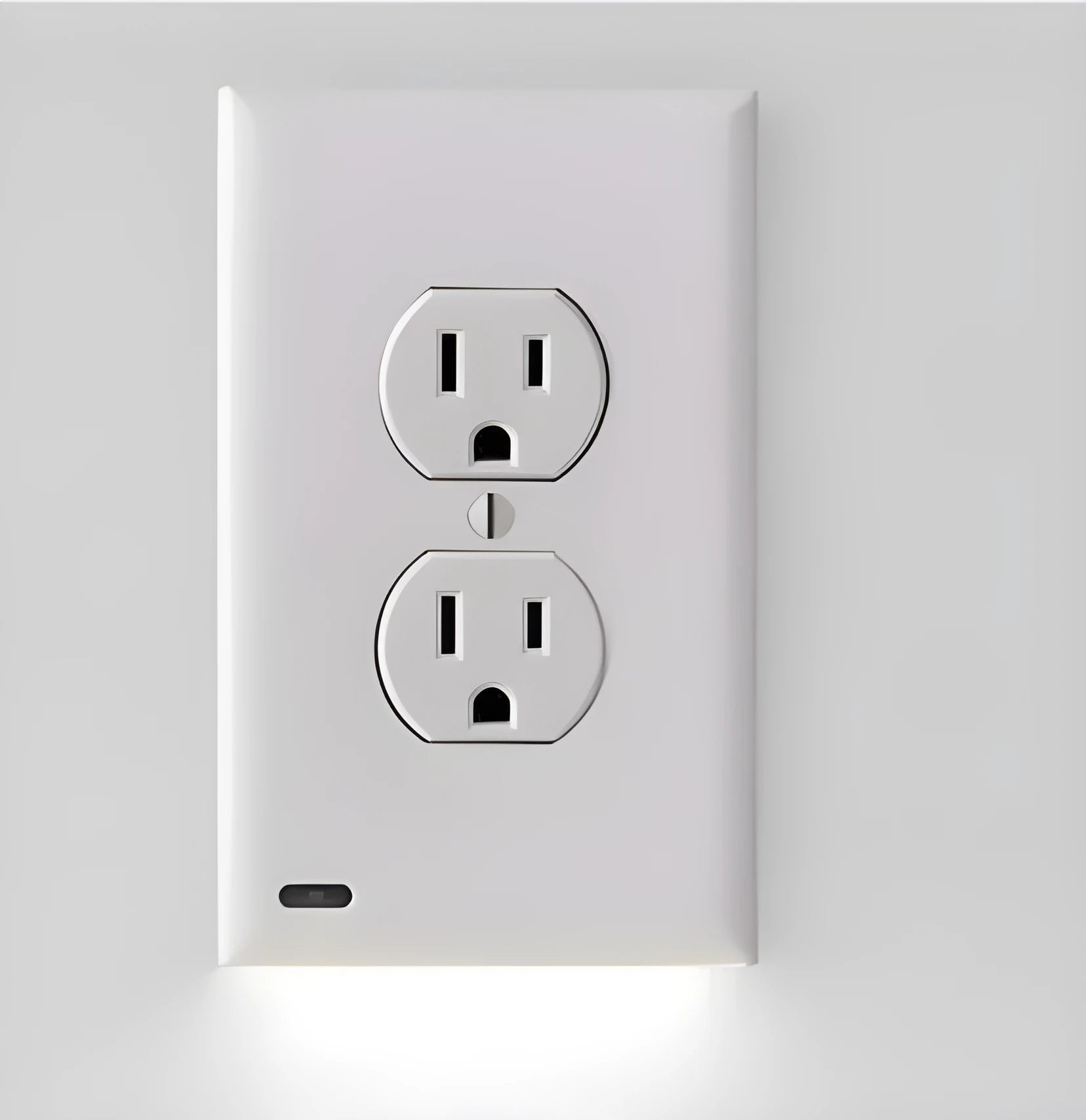 White plug-in LED sensor night light installed in a wall socket