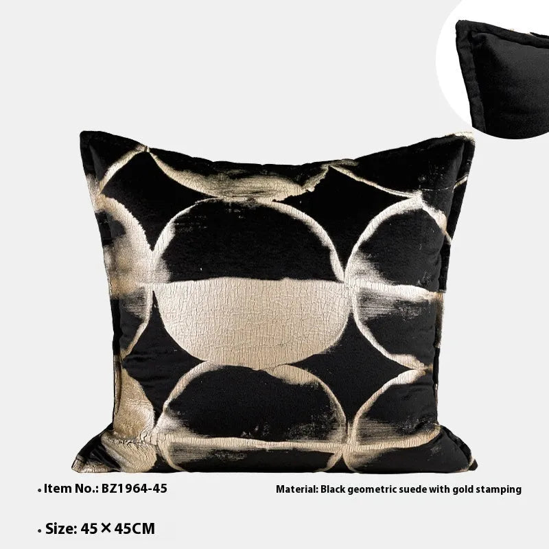 Black gold abstract patterned square decorative pillow with a soft flannel texture on a grey sofa.