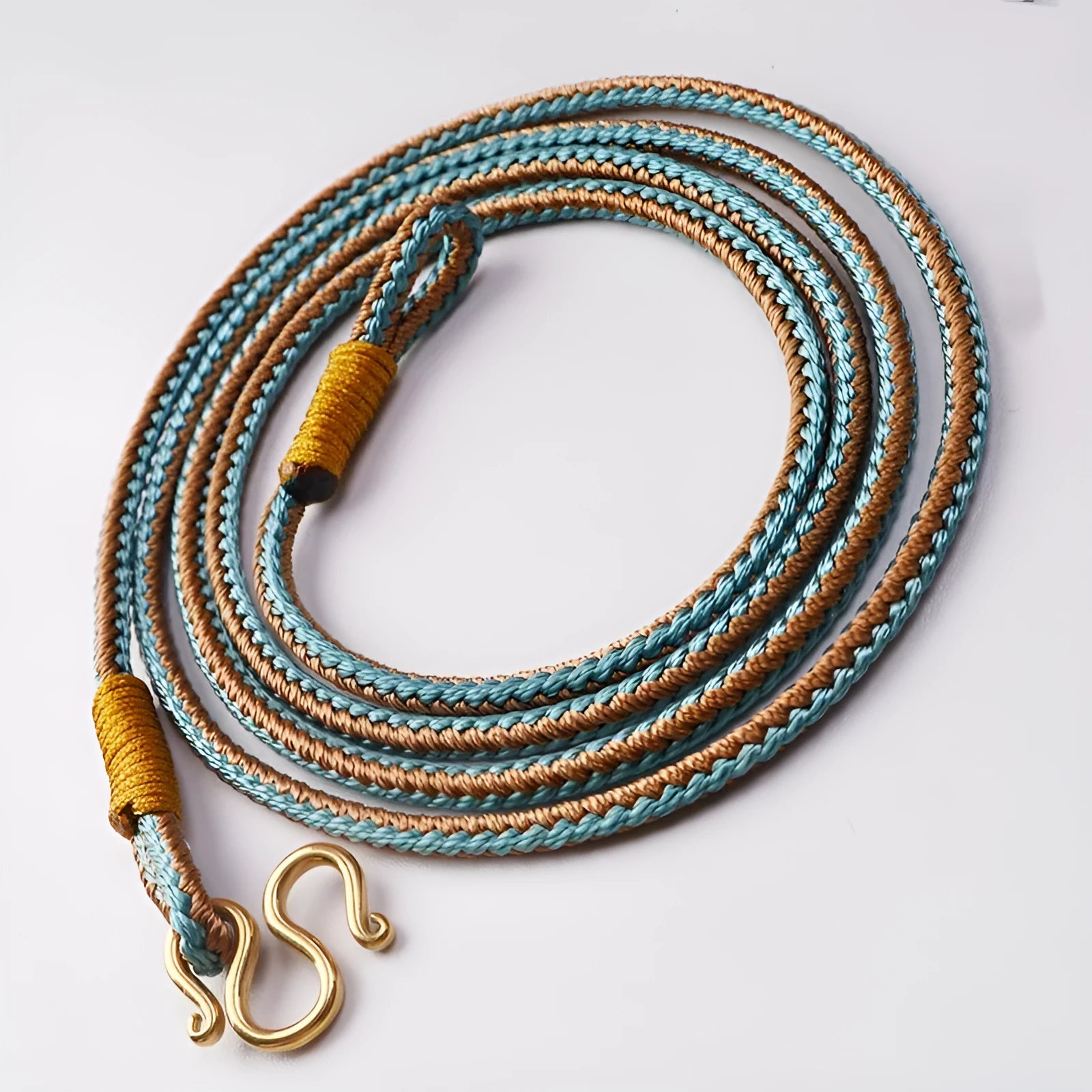 Gold and silver Thangka Peace Buckle pendant with imitation pearl and mixed gem inlays on a necklace.