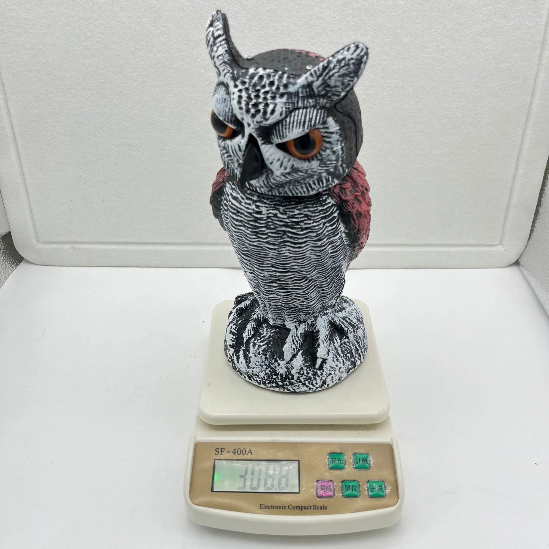 Artificial owl bird deterrent ornament with moving head in outdoor setting