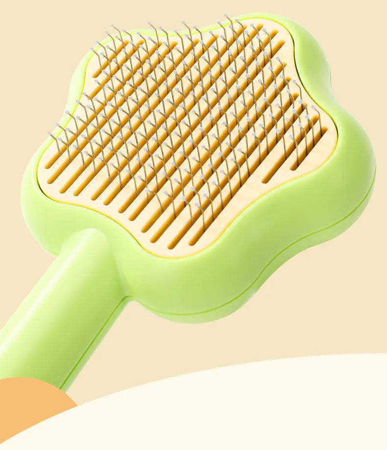 Green self-cleaning stainless steel pet comb with removable needle head on a white background.