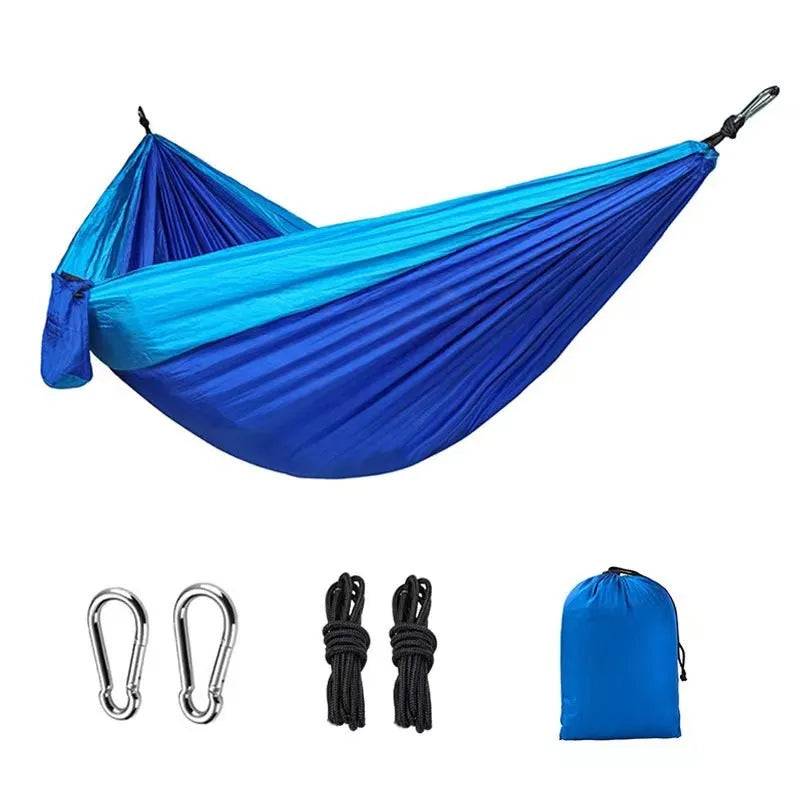 Blue nylon parachute cloth camping hammock hung between trees, showing its 270cm length.