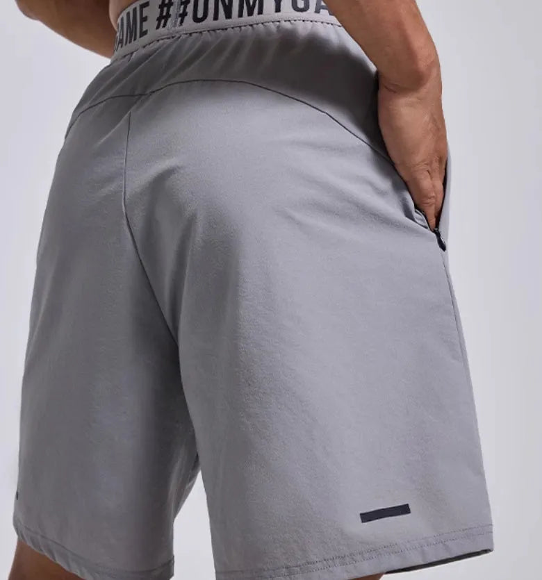 Man wearing loose grey sports shorts with an elastic waistband during a workout.