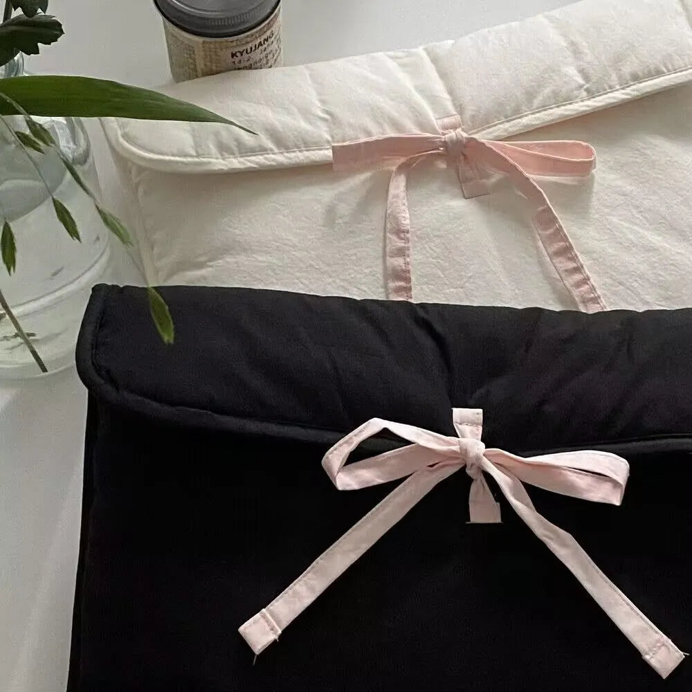 Women's black quilted laptop bag with ballet bow detail and striped pattern showing 11-inch size