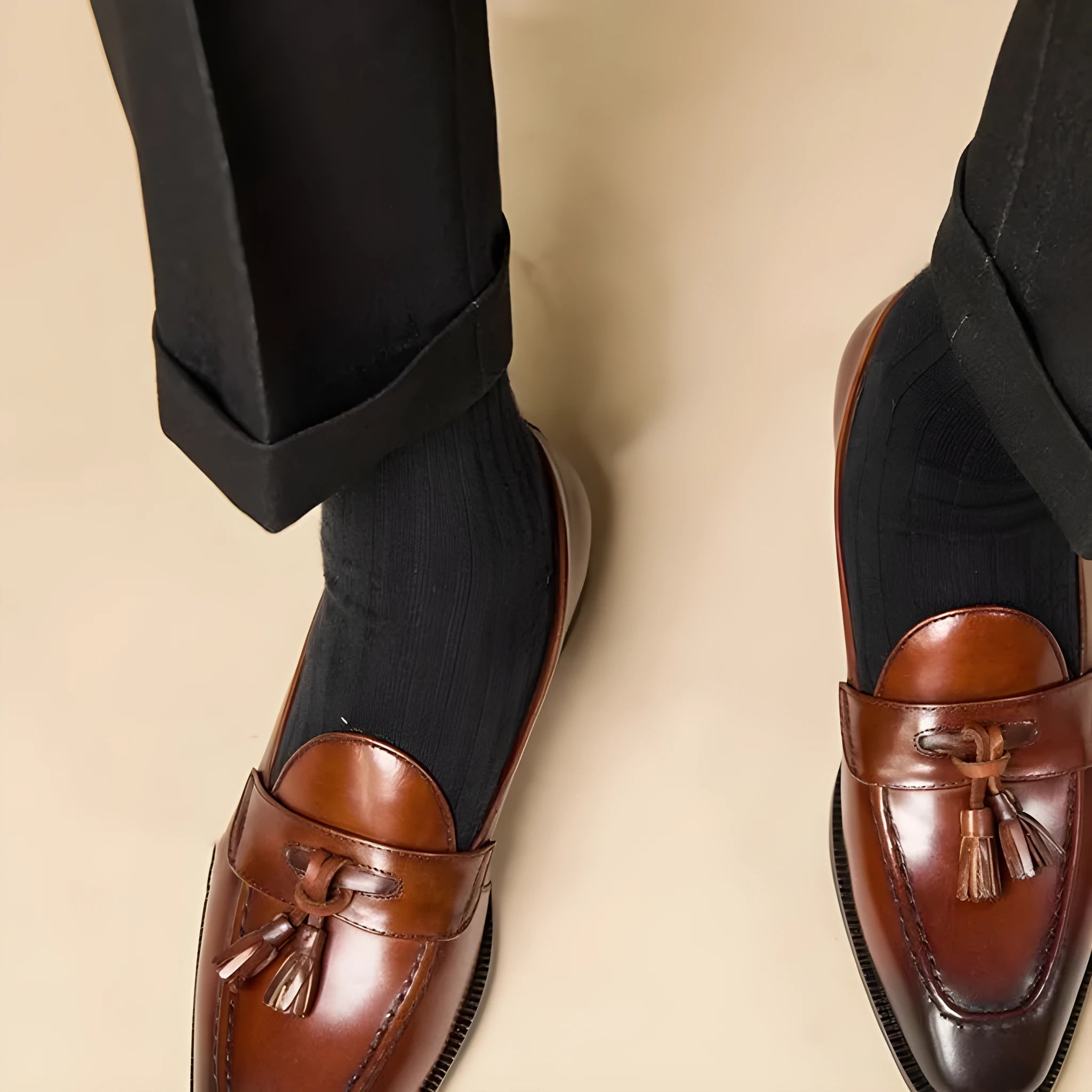 Black leather tassel loafers with polished finish and decorative tassel detail