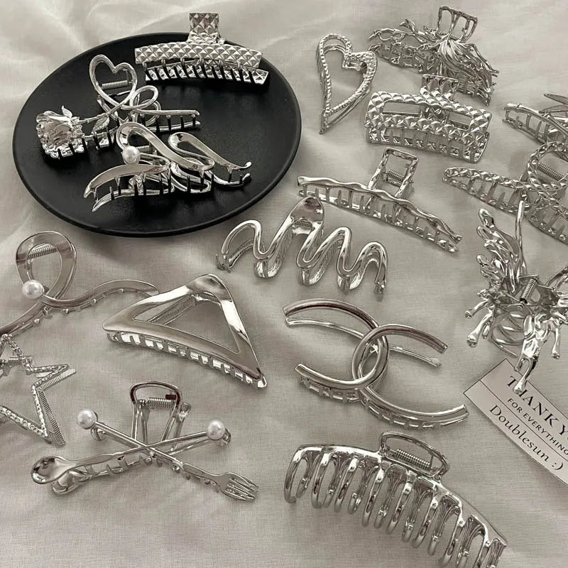 Silver metal hair claw barrettes collection showing multiple designs including wave, rose, and bow shapes