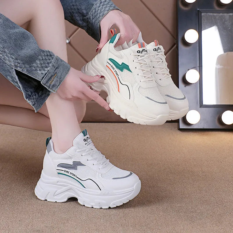 Women's white and beige dad shoes with lace-up front and rubber sole showing mesh material detail