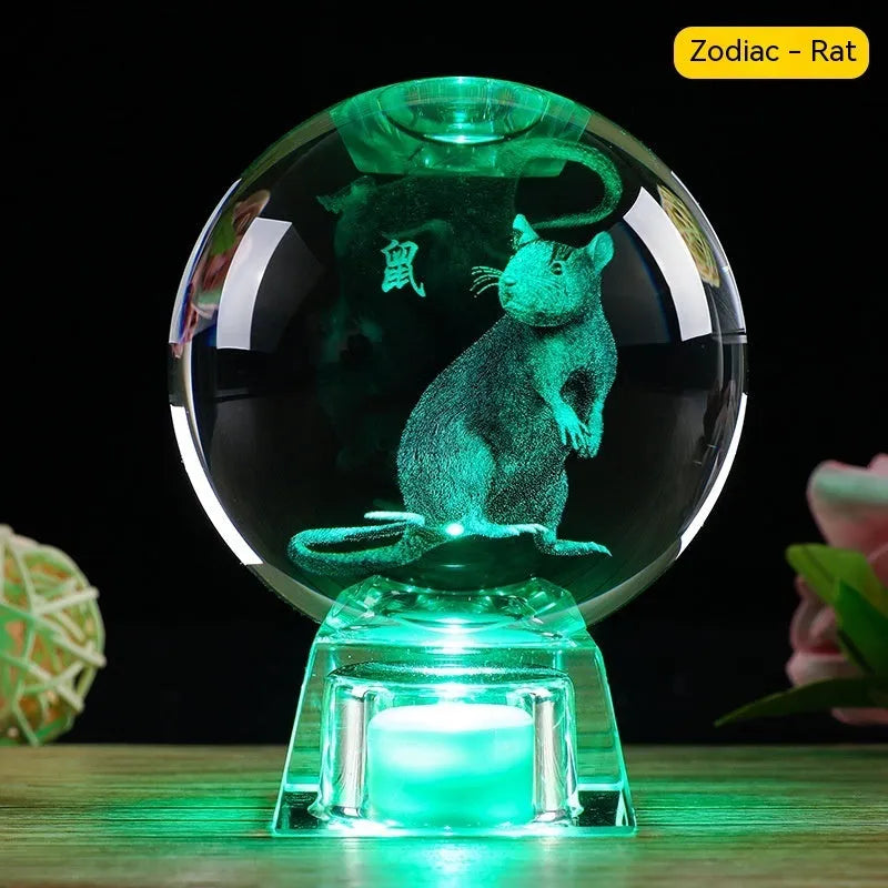 White luminous crystal ball ornament with Chinese zodiac animal figure on electronic base.