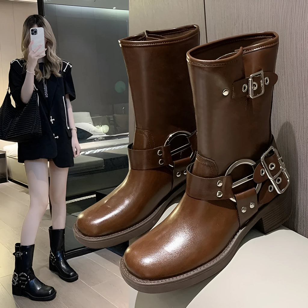 Women's black platform boots with a large silver belt buckle and mid-calf height.