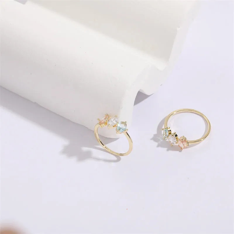 Geometric triangle ring with tricolour zircon birthstone in gold electroplated finish.