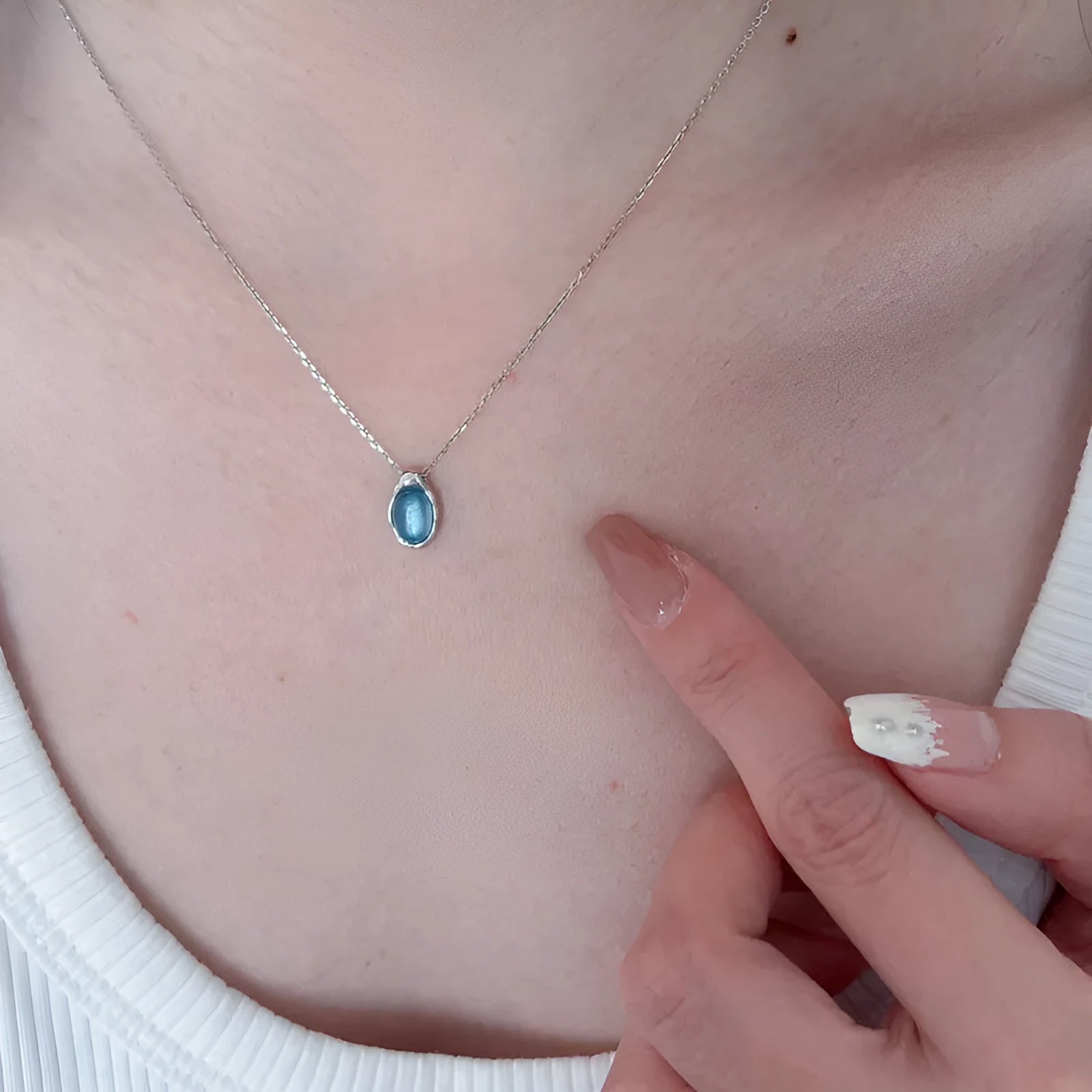 Navy blue geometric water drop pendant necklace with cross chain design on white background