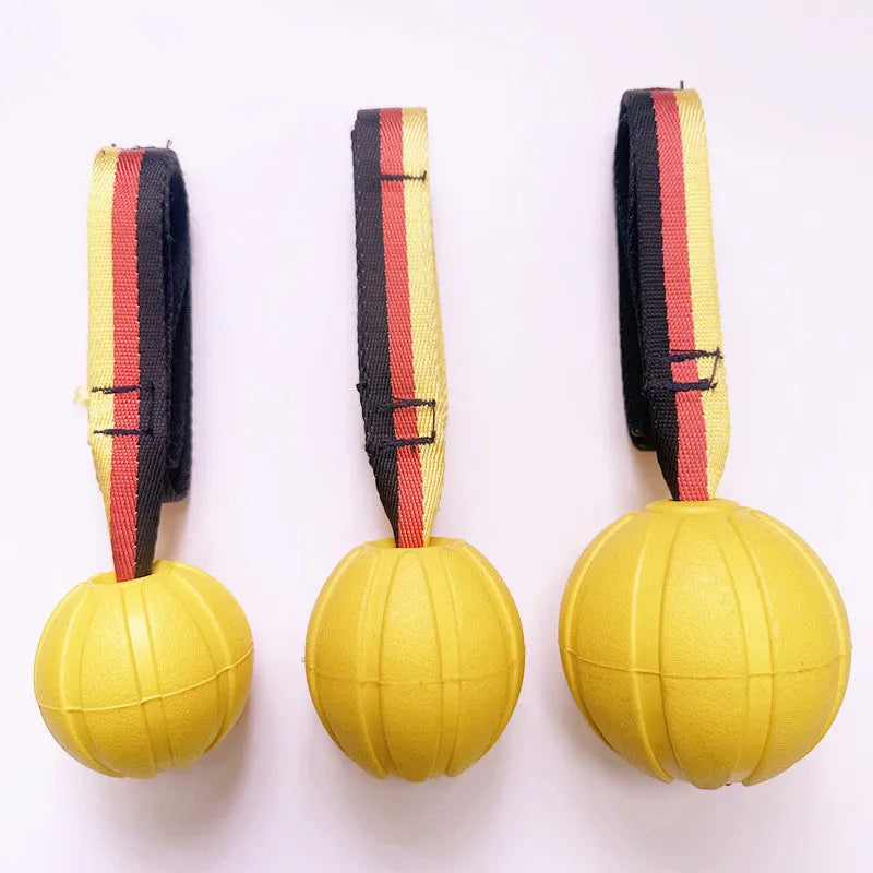Floating EVA tetherball dog toy in yellow with attached retrieval string on water surface