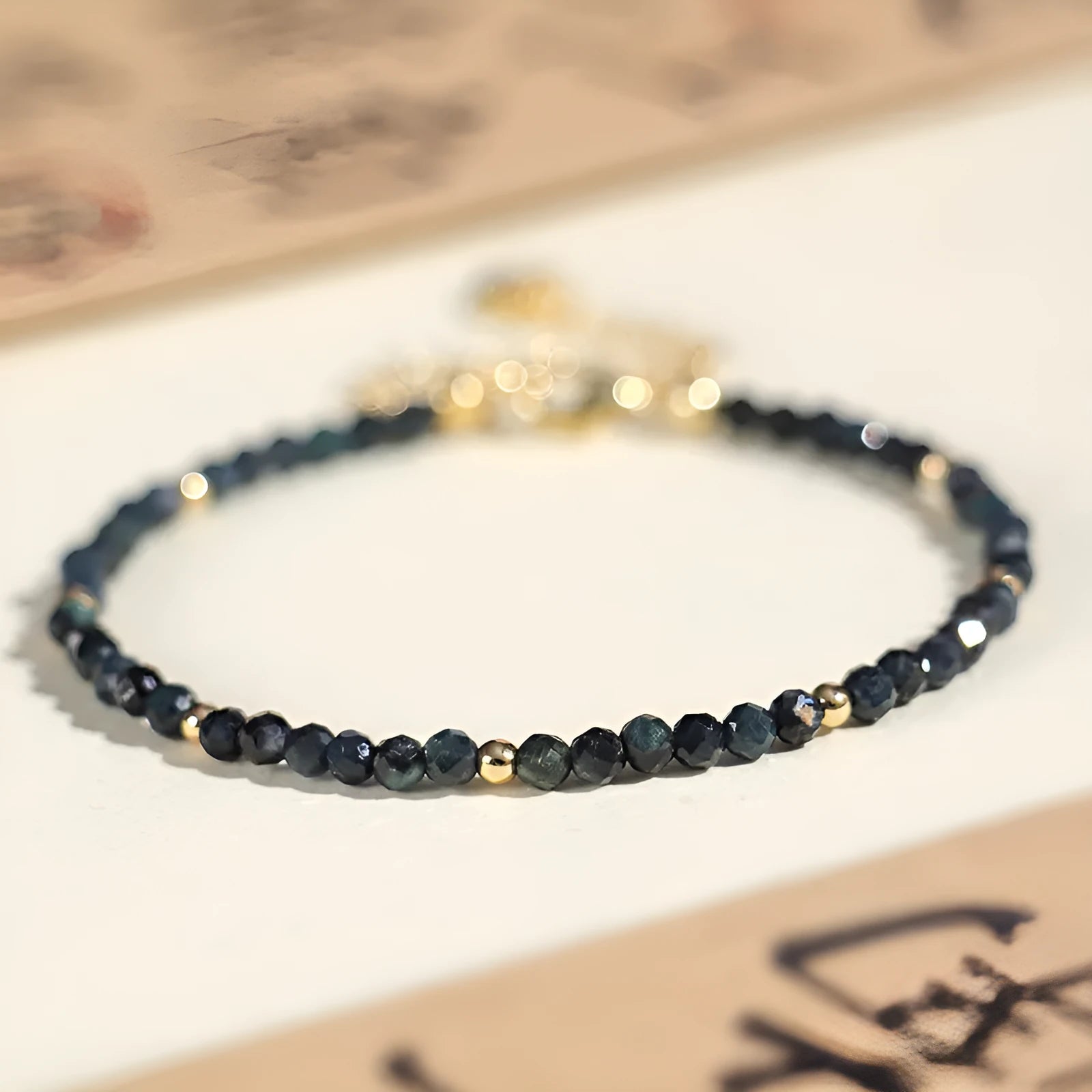 Blue tourmaline bracelet with 3mm cut beads and spacer design on white background