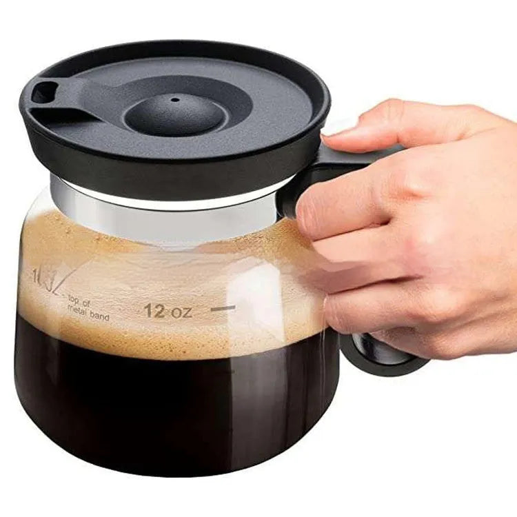 Transparent borosilicate glass coffee maker with black silicone cover on a kitchen counter.