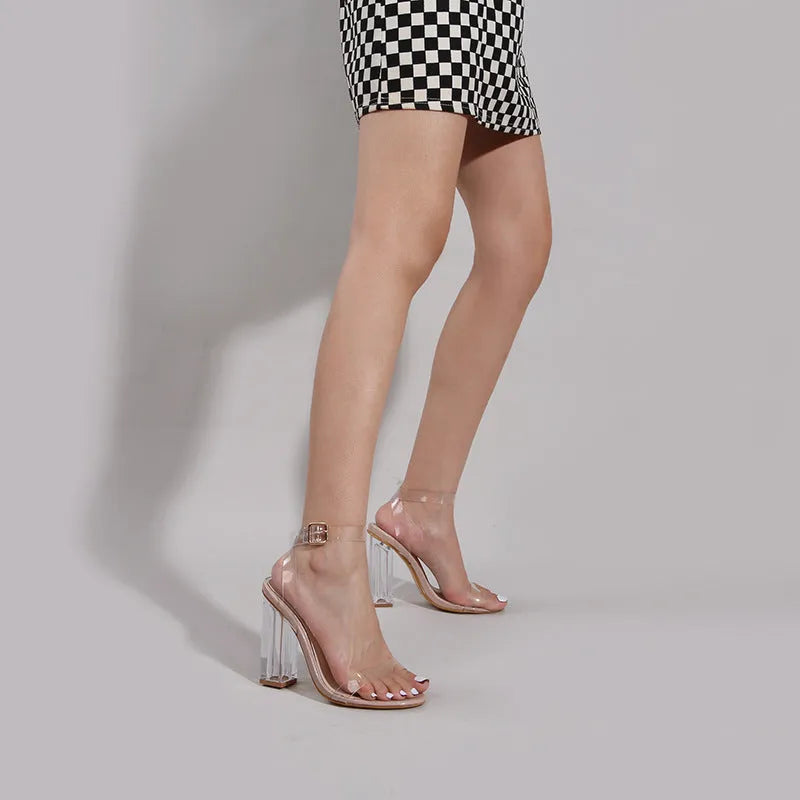 Apricot-coloured women's high heel sandals with clear glass heels and an ankle buckle strap.