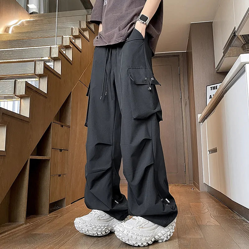 Women's plus size loose-fit waterproof trousers in black, shown with elasticated waist and straight leg.