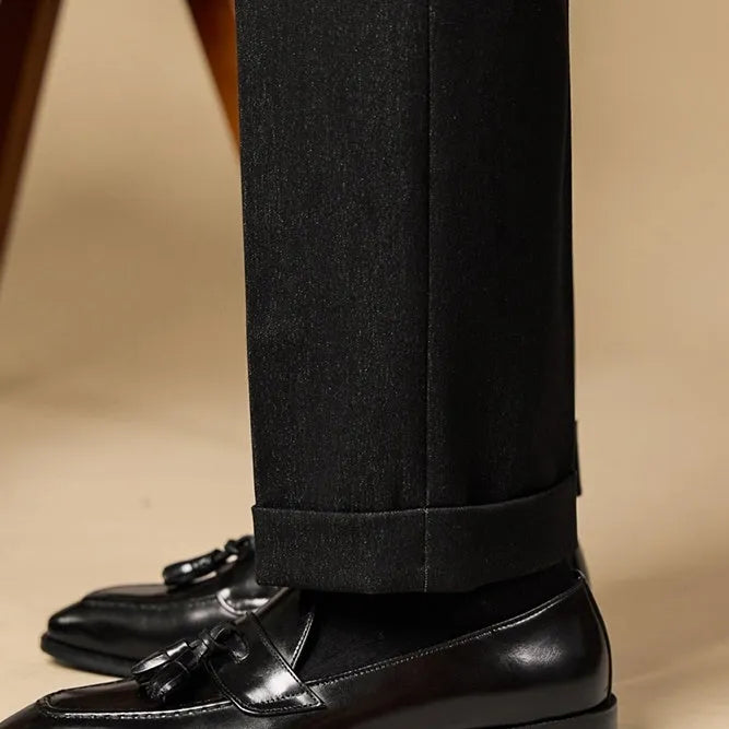 Black leather tassel loafers with polished finish and decorative tassel detail