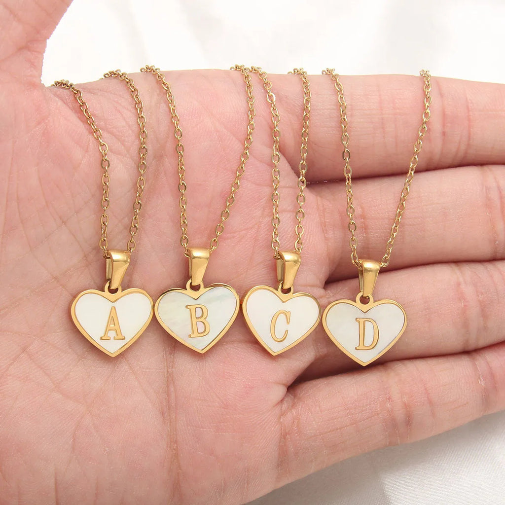 Gold chain necklace with white shell heart pendant featuring single letter customisation option