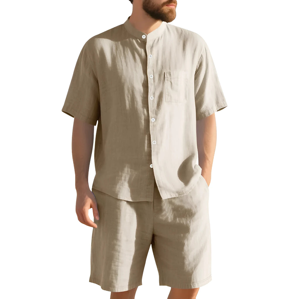 Man wearing a light blue linen blend Henry collar short sleeve suit top with matching shorts.