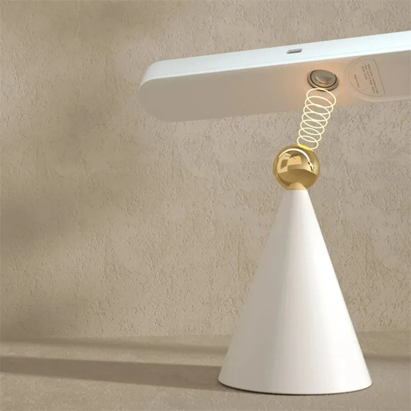 White geometric desk lamp with USB cable and magnetic base for wall mounting.