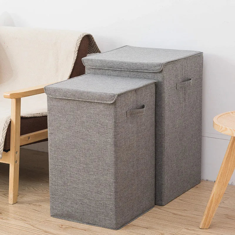 Grey foldable cotton linen storage basket shown next to a folded towel and a book.