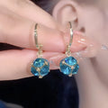 A pair of women's geometric rose design earrings in electroplated copper with zircon detail.