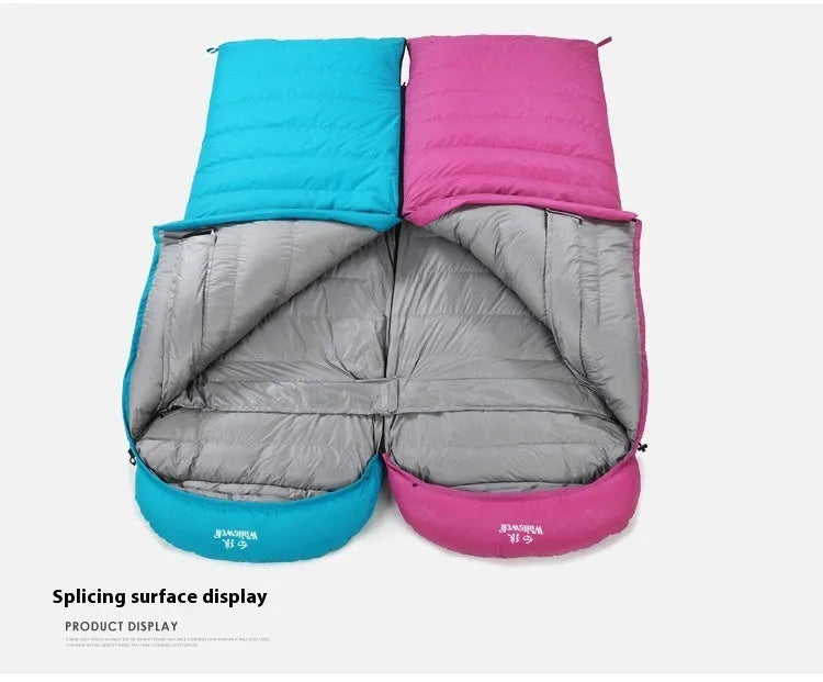 Black outdoor sleeping bag with envelope structure and goose down fill on a campsite.