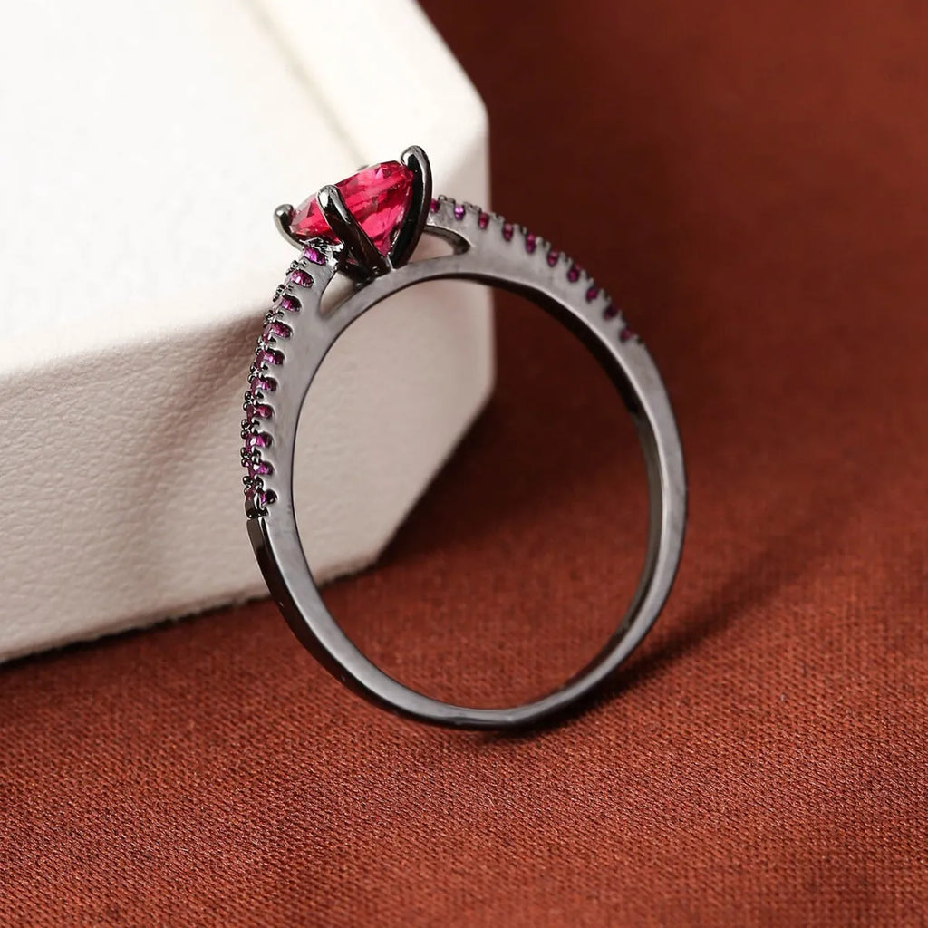 A geometric hexagonal zircon ring in copper, shown in a gold rose red electroplated finish on a size 7 finger.
