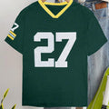 Man's loose fit red cotton t-shirt with a digital print of contrasting green letters on the front.