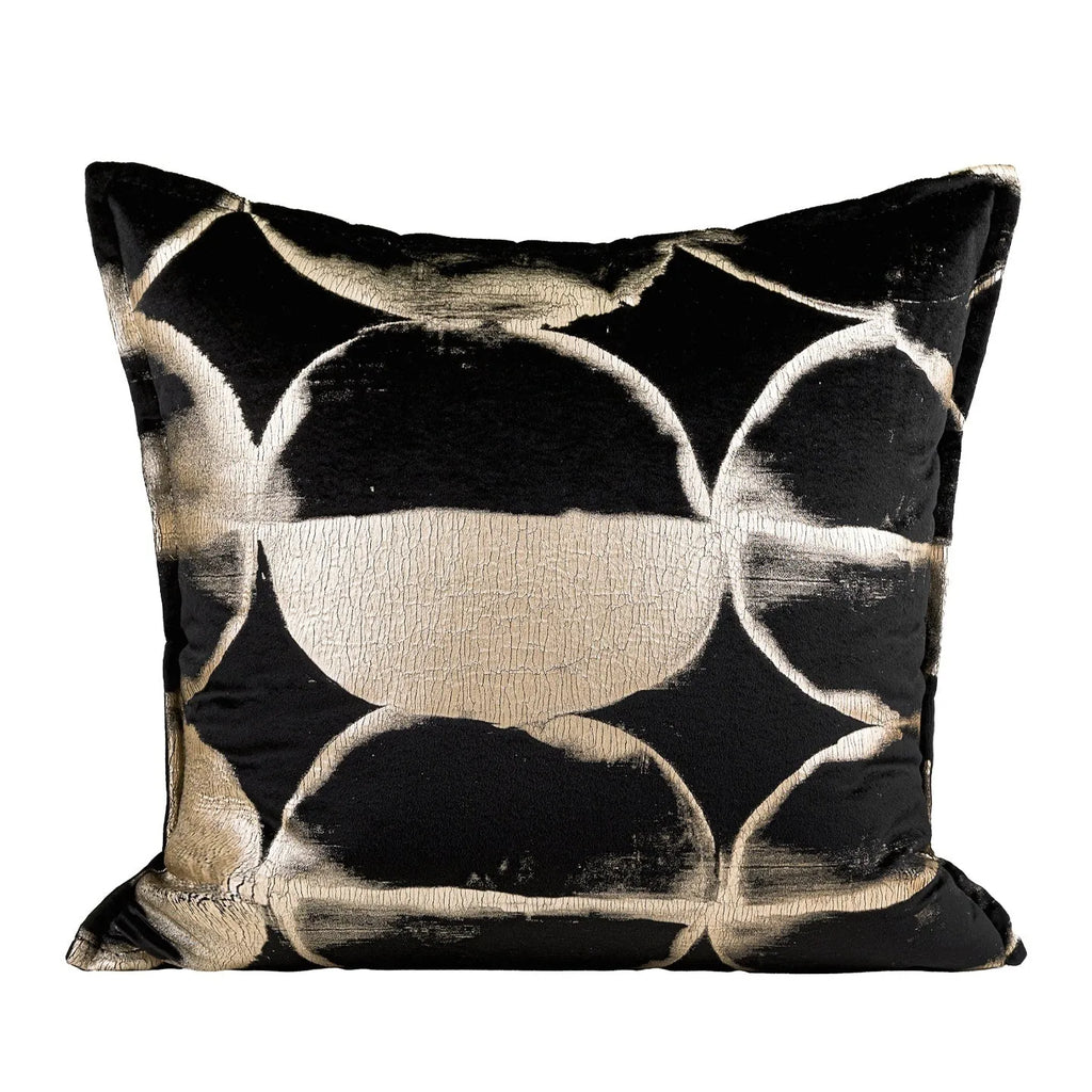 Black gold abstract patterned square decorative pillow with a soft flannel texture on a grey sofa.